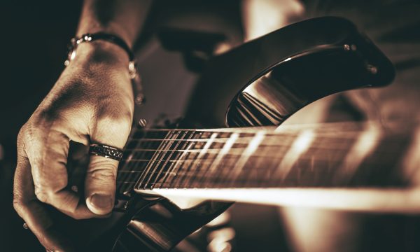 Guitarist Plays. Electric Guitar Playing Closeup Photo. Rockman Guitar Player Music Theme.